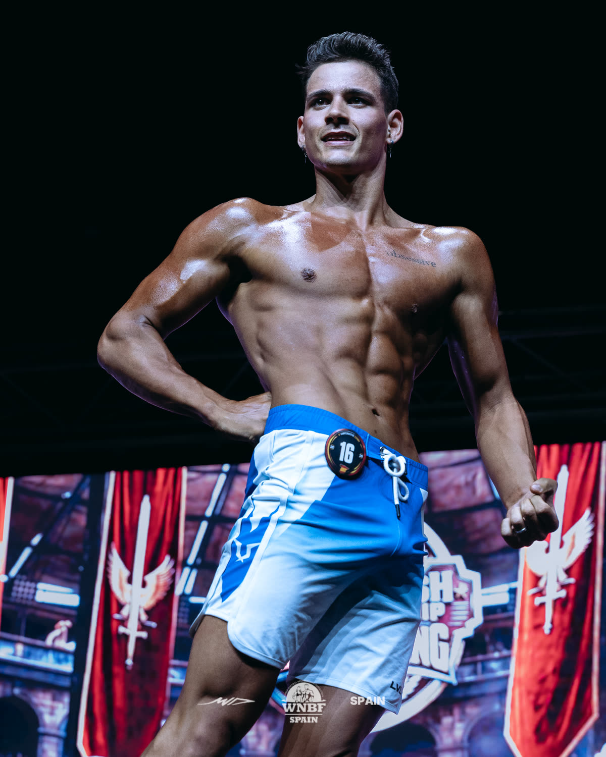 Alex Carrasco posando en el escenario de un campeonato de culturismo natural de la WNBF Spain